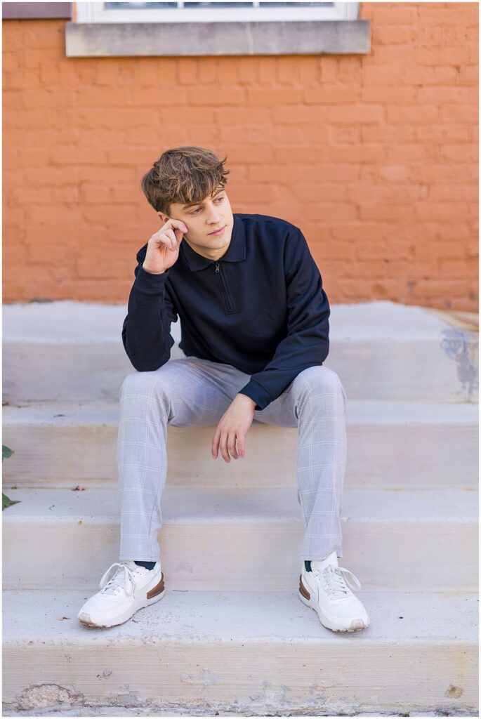 senior guy sitting on stairs looking into the distance