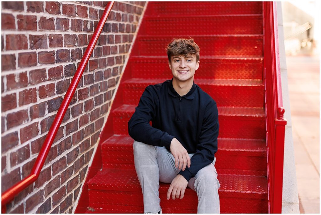 senior guy on red stairs in senior photos