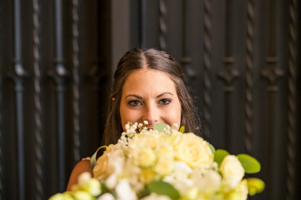 Bride peaking over flowers photo
