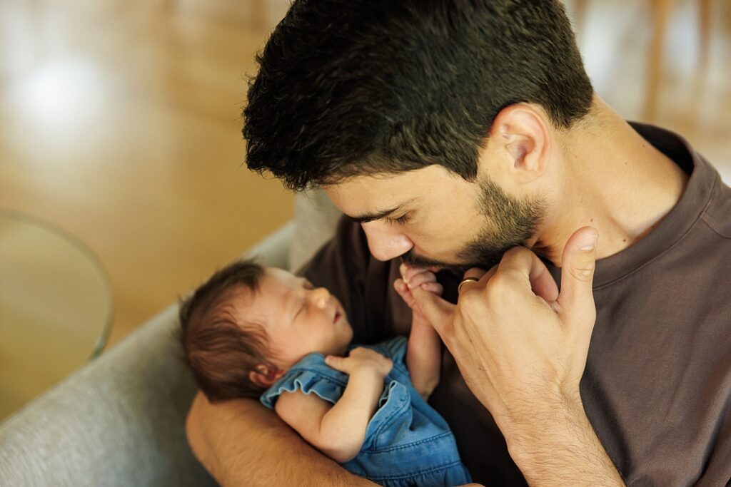Newborn girl holding dad's finger photo